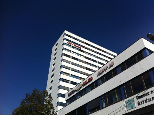 Ein hohes weißes Gebäude mit einem Schild drauf. in der Unterkunft City Hotel Heilbronn in Heilbronn