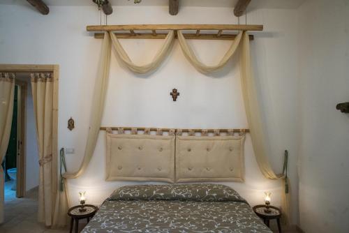 a bedroom with a bed and two lamps on tables at Agriturismo Grotta Di Figazzano in Cisternino