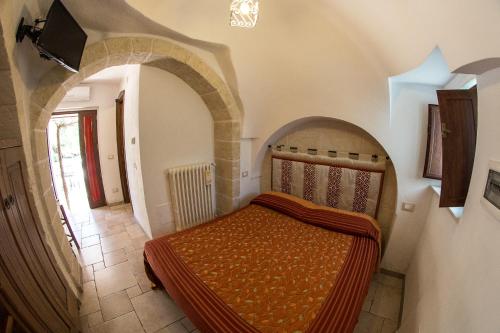 a bedroom with a bed in a room with an arch at Agriturismo Grotta Di Figazzano in Cisternino