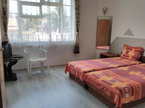 ein Schlafzimmer mit einem Bett, einem Stuhl und einem Fenster in der Unterkunft Prima Guest House 2 in Sweti Konstantin
