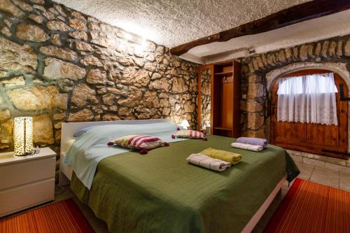 a bedroom with a large bed in a stone wall at apartman SONJA in Risika