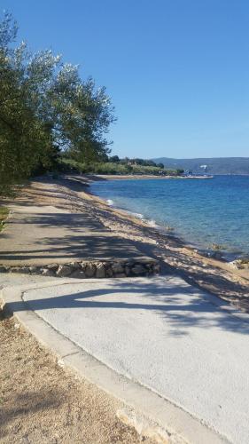 a road next to the water with trees on it at Gavza Sky View Apartment in Cres