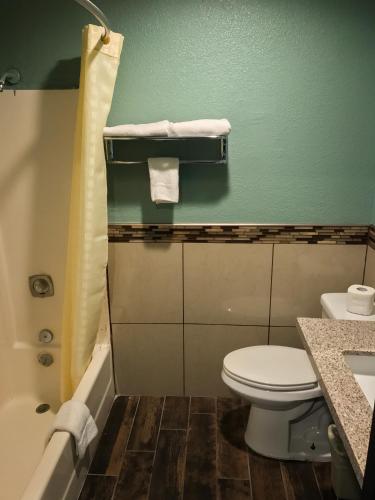 a bathroom with a toilet and a sink and a tub at Highland Park Motel in Los Angeles