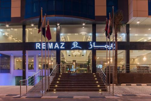 a set of stairs in front of a building with flags at Remaz Suites Hotel in Al Jubail