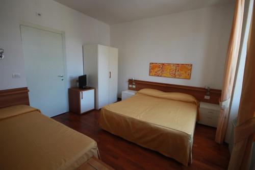 - une petite chambre avec 2 lits et une télévision dans l'établissement Affittacamere Bel Sole, à Borghetto di Vara