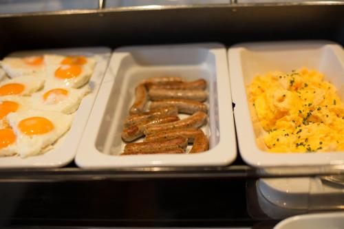 a tray of breakfast food with eggs sausage and potatoes at Hotel Heiligenstein in Baden-Baden