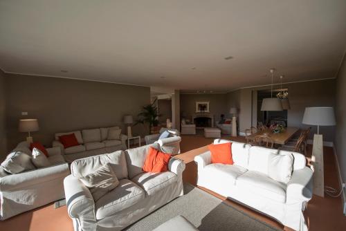 a living room with white couches and orange pillows at Agriturismo Tenuta "Il Cigno" in Villanterio