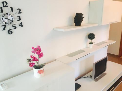 Un escritorio blanco con un ordenador y flores. en Apartment Leonardo, en Biograd na Moru