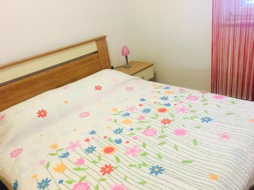 ein Schlafzimmer mit einem Bett mit Blumen darauf in der Unterkunft Apartment Leonardo in Biograd na Moru