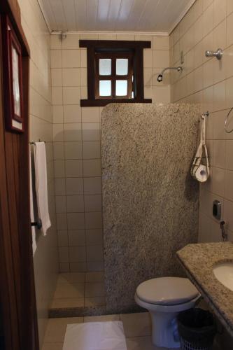 a bathroom with a shower with a toilet and a sink at Pousada Varandas da Serra in Serra do Cipo