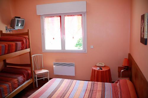 sypialnia z łóżkiem i oknem w obiekcie Hôtel - Pub Le Petit Bosquet w mieście Santo-Pietro-di-Venaco