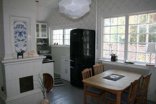 a kitchen with a table and a black refrigerator at Villa Gräsdalen in Karlstad