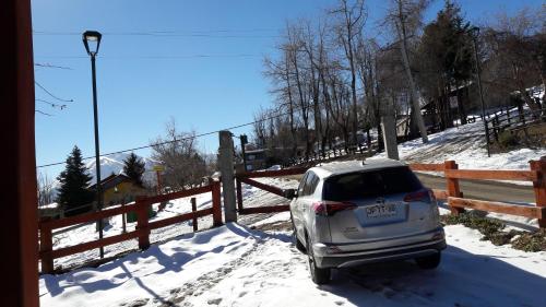 a car parked in the snow next to a fence at Great Chalet Farellones in Farellones