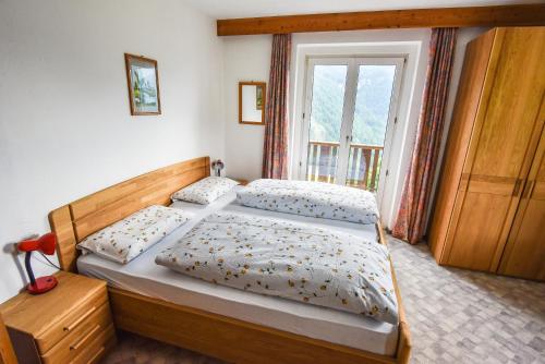 um quarto com 2 camas e uma janela em Albergo Somont em Ortisei