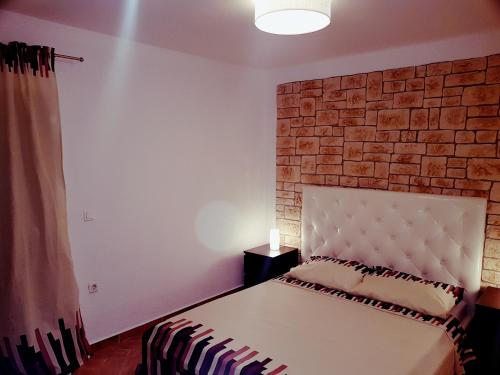 a bed in a room with a brick wall at DolceFarNiente Fažana in Fažana