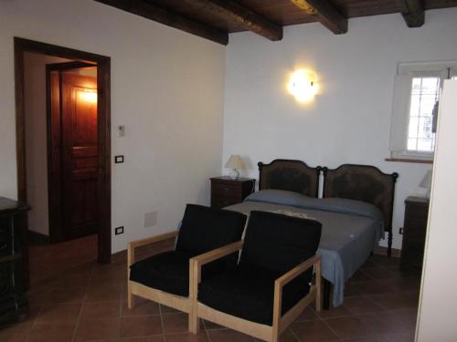 1 dormitorio con 1 cama y 2 sillas en B&B AL BRIC, en San Raffaele Cimena