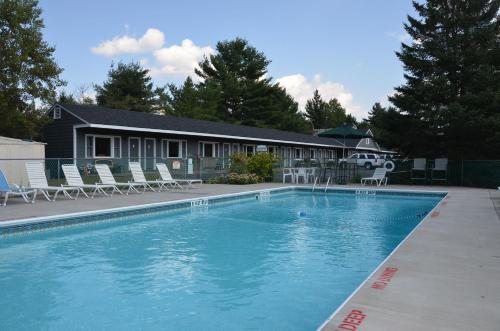 uma grande piscina com cadeiras e uma casa em Grand View Motel em Wilmington