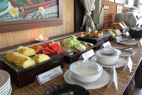 a buffet with food on a table with bowls of food at Adi Dharma Hotel Legian in Legian