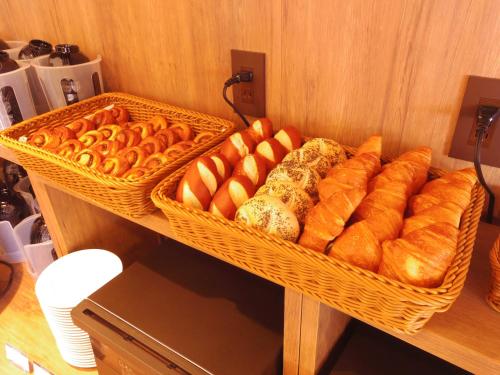 un panier de pain et de viennoiseries sur une étagère dans l'établissement Hotel Route-Inn Kumamoto Ekimae, à Kumamoto