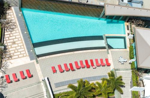 an overhead view of a swimming pool with red chairs at Aria Apartments in Gold Coast