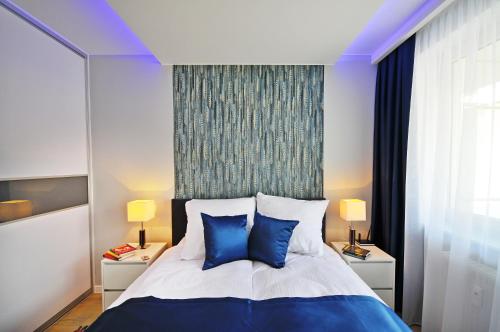 コウォブジェクにあるGrey & Green Apartmentsのベッドルーム1室(青と白のベッド、青の枕付)