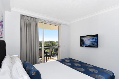 a bedroom with a bed and a balcony at Palazzo Colonnades in Gold Coast
