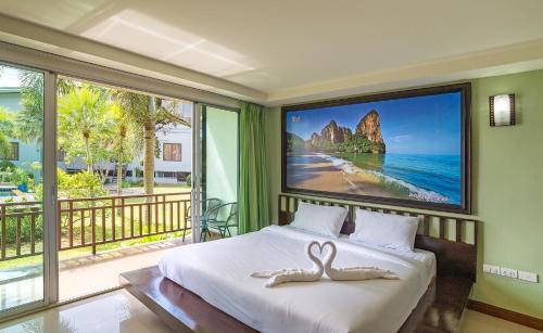a bedroom with a bed with a picture of the beach at Krabi Home Town Boutique in Krabi town