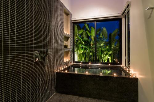 a bathroom with a window with a plant in it at Monthara Angkor Residence in Siem Reap