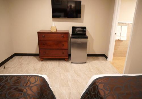 a bedroom with a dresser and a tv on the wall at Beachside Resort in Wildwood