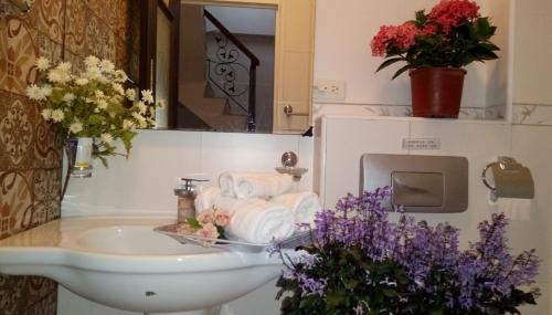 baño con lavabo, toallas y flores en Victoria B&B, en Luodong