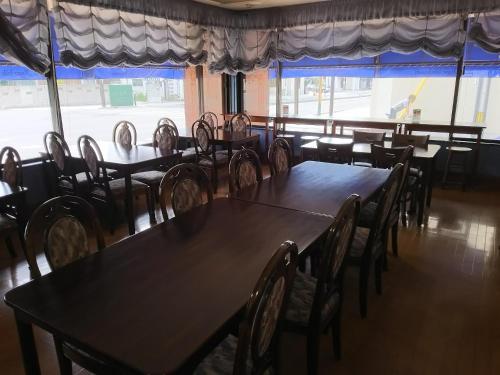 a dining room with tables and chairs and a window at Hotel Hyper Hills Hirosaki in Hirosaki