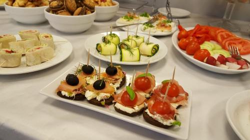 a table with plates of appetizers and plates of food at Hotel Sokołowska Airport Modlin in Nowy Dwór Mazowiecki