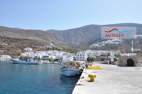 a boat is docked in a body of water at Hotel Agnadi in Amorgos