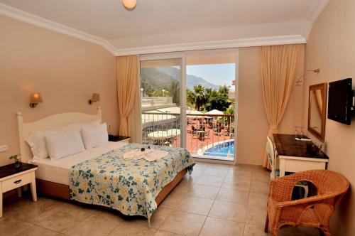 Schlafzimmer mit einem Bett und Poolblick in der Unterkunft The Blue Lagoon Deluxe Hotel in Oludeniz