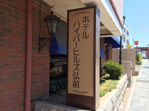 a sign outside of a building with asian writing on it at Hotel Hyper Hills Hirosaki in Hirosaki