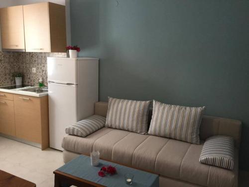 a living room with a couch and a white refrigerator at Sea Sound in Vasiliki