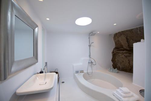 a bathroom with a large tub and a sink at Diles Villas & Suites Mykonos in Tourlos