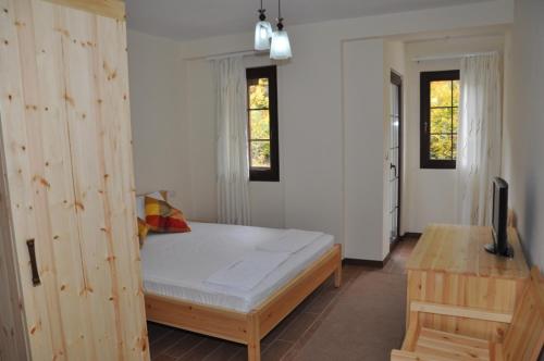 um quarto com uma cama e uma televisão em Hotel Marub em Rubik