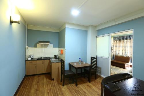 - une petite cuisine avec une table et un comptoir dans l'établissement Aarya Chaitya Inn, à Katmandou