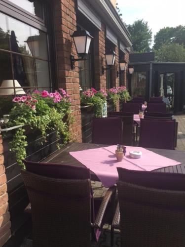 a pink table and chairs sitting on a patio at Hotel im Park in Haan