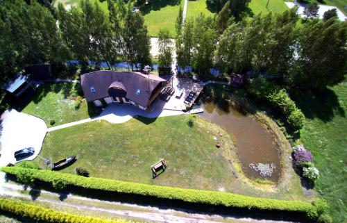 an aerial view of a house with a pond at Piejūras Nams in Ķesterciems