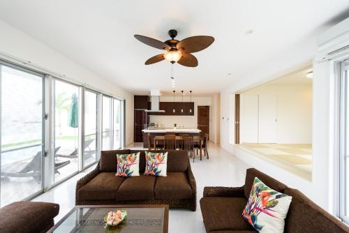 a living room with a couch and a ceiling fan at Coldio Marina Kin in Kin