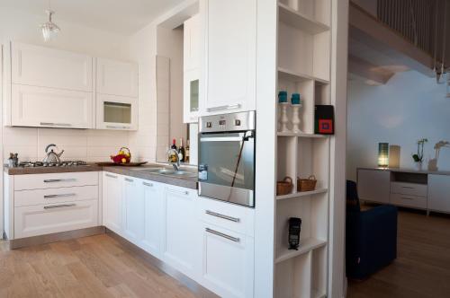 a kitchen with white cabinets and a stove top oven at Quiet Home Terracina Apartments in Terracina
