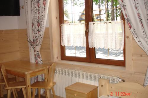 a room with a window and a table and chairs at Domek, Apartamenty i pokoje Willa Elita in Kościelisko