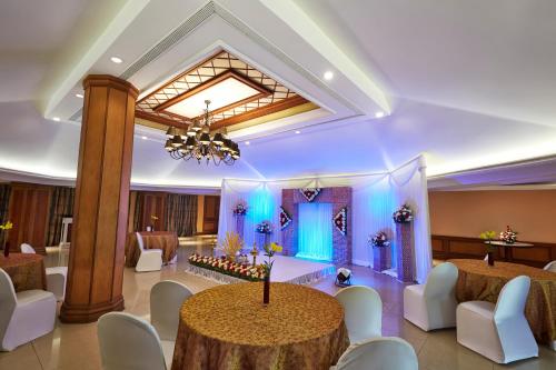 a banquet hall with a round table and chairs at The Gateway Hotel Beach Road, Calicut in Kozhikode