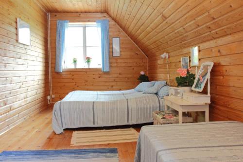 a bedroom with two beds in a wooden cabin at Hommik House in Otepää