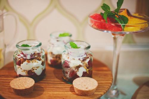 a wooden table with jars of desserts and a martini at Last Word Constantia in Cape Town