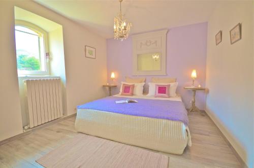 Robion en LuberonにあるFerme St Rochのベッドルーム1室(紫色のシーツと枕が備わる大型ベッド1台付)