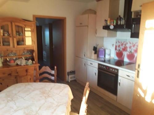 a kitchen with a table and a stove top oven at Ferienwohnung Stadie in Dörphof