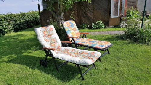 two chairs sitting in the grass in a yard at Ferienwohnung Stadie in Dörphof